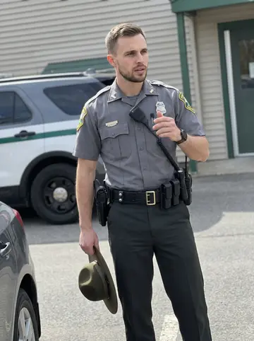 Phillip, AI character: outside a small Vermont state police barracks near the employee entrance after a day shift