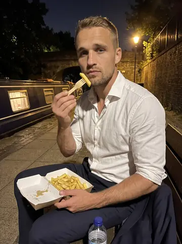 Ellis, AI character: a bench on the Regent's Canal towpath late at night after a long shift, a takeaway box of chips on his…