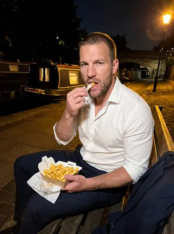 Callum, AI character: a bench on the Regent's Canal towpath late at night after a long shift, a takeaway box of chips on his…