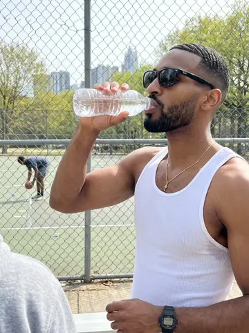 Lorenzo, AI character: Sunday-morning pickup at the outdoor basketball courts in Piedmont Park, chain-link fence, green trees and…