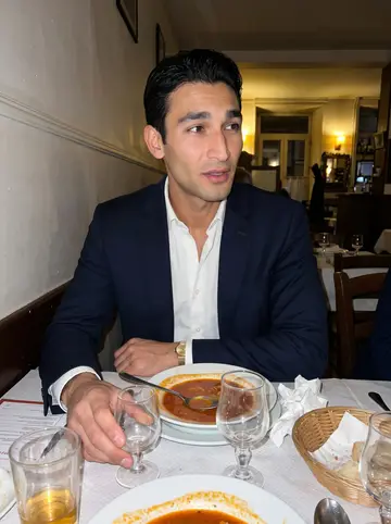 Rudy, AI character: a small old Marseille restaurant during a late family dinner, plates of bouillabaisse and half-empty…