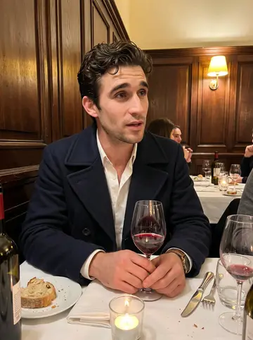 Bilal, AI character: a licence commission dinner in a small Marseille restaurant, white tablecloths, wine glasses, and dark…