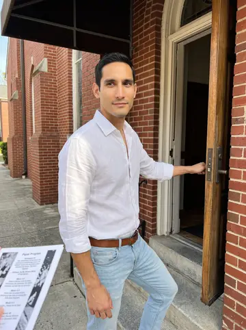 Yeison, AI character: outside a small Atlanta church after Sunday service, holding the side door open for someone behind the camera