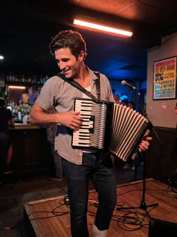 Grady, AI character: a small Bywater bar on Thursday zydeco night, standing near the corner stage with his accordion