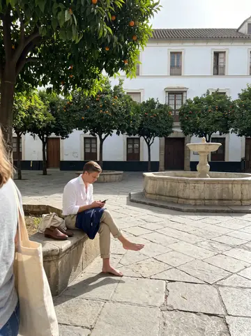 Kane, AI character: a pedestrian street in Málaga old town on a bright April morning, stone paving, orange trees and shop awnings