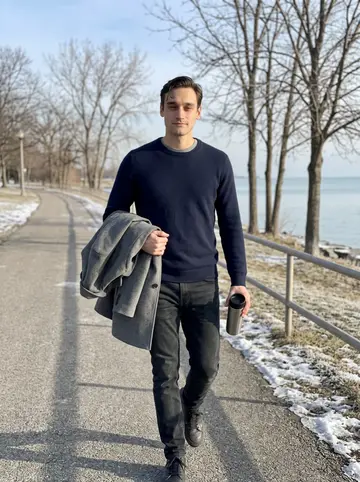 Zackary, AI character: the paved path by Lake Erie at Edgewater Park after his cold-water morning swim, bare trees and pale lake…