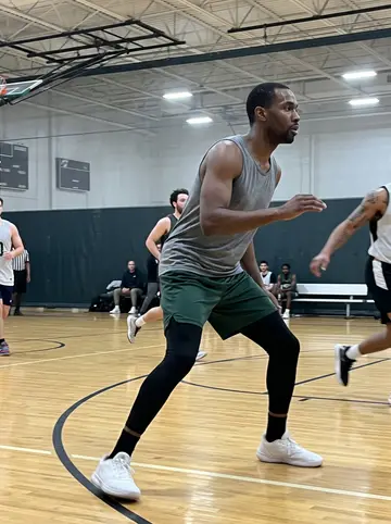 Rotimi, AI character: Decatur rec center basketball court on a winter evening, glossy floor and wall padding behind him