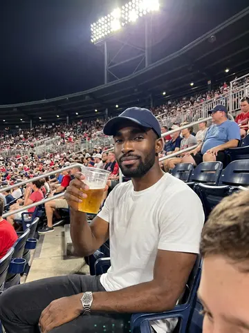 Marcus, AI character: the upper deck at an Atlanta baseball game on a hot summer night, the field lights and crowd behind