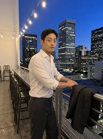 Aiden, AI character: the rooftop bar of the downtown Los Angeles hotel he runs, just after closing, stools stacked and towers…