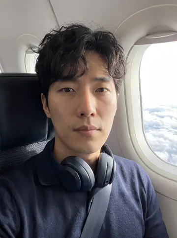Daniel, AI character: a window seat on a morning work flight, clouds and bright sky outside