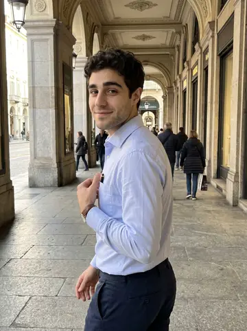 Alan, AI character: the covered arcades near Piazza San Carlo in Turin, late afternoon after a legal clinic shift