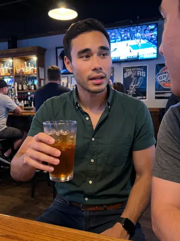 Ricardo, AI character: a casual San Antonio sports bar with a Spurs game on the TV in the background