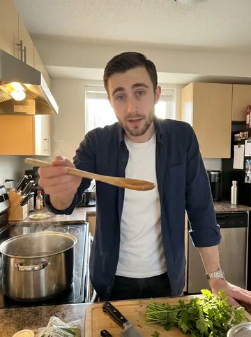 Steven, AI character: his apartment kitchen on a Sunday evening, stock pot on the stove and cutting board crowded with herbs