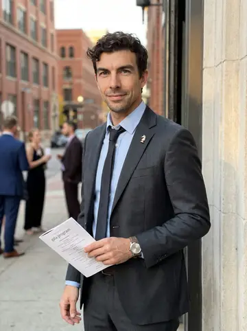 Justin, AI character: outside a Minneapolis event hall before the family-law gala, standing in the doorway with downtown brick…