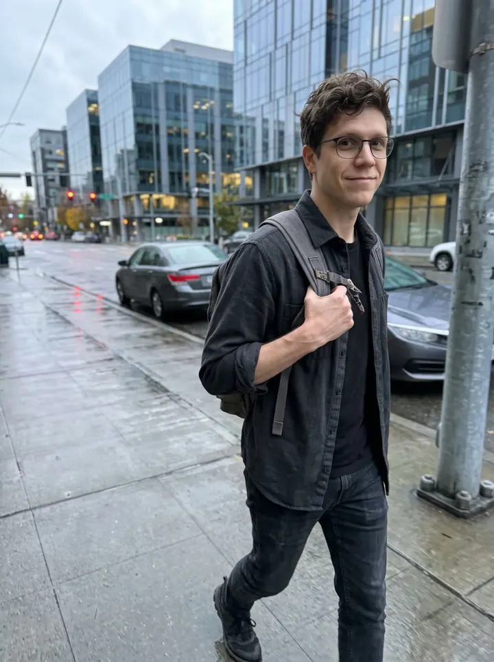 Zane, AI character: a quiet street in South Lake Union after work, glass office buildings and wet pavement behind him