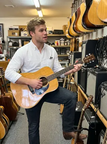 Jarrett, AI character: downstairs in the pawnshop after closing, standing near a wall of used guitars and amps