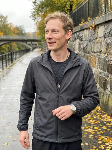 Morten, AI character: Akerselva path on a damp Sunday morning, fallen yellow leaves along the river wall