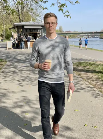 Matěj, AI character: a quiet path beside the Main river on a bright Sunday morning, walking away from a small coffee kiosk