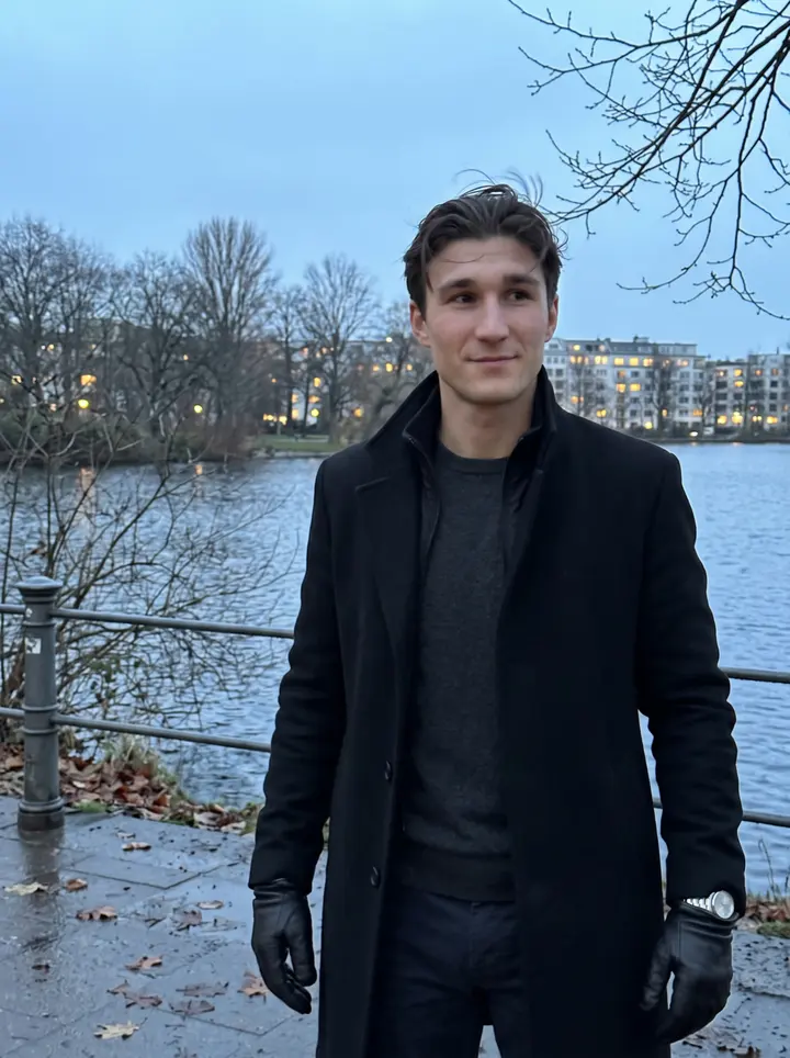 Lennart, AI character: beside the Außenalster in Hamburg at blue hour, bare winter trees and cold water behind him