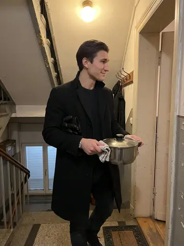 Lennart, AI character: the narrow stairwell of his Hamburg apartment building above the closed bakery, outside Frau Brandt's door