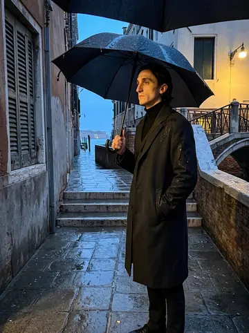 Anatole, AI character: a narrow calle in Venice in November at dusk, wet stone, a small bridge over a dark canal, shuttered windows