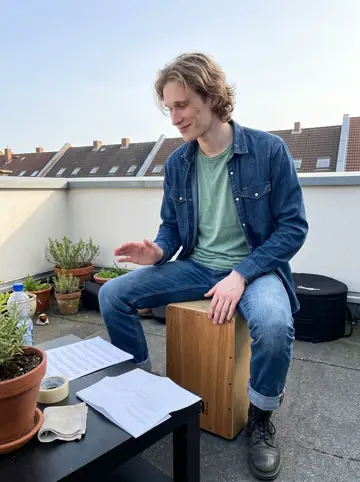 Linus, AI character: his apartment rooftop in Hamburg on a clear spring afternoon, phone propped on a low table while he…