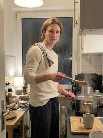 Linus, AI character: small apartment kitchen in Hamburg on a cold night, a soup pot on the stove and condensation on the window