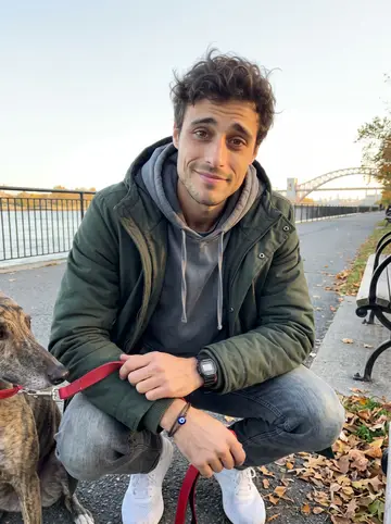 Lazaros, AI character: Astoria Park near the East River path just after sunrise, crouched beside Niko the brindle greyhound with…
