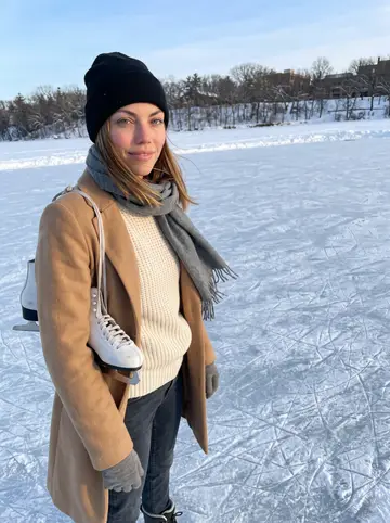Saskia, AI character: the frozen lake near the University of Minnesota campus just after sunrise, with skate marks on the ice…
