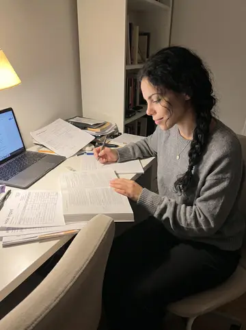 Yurany, AI character: her bedroom desk after midnight, accounting textbook open beside a laptop and a small stack of wine import…