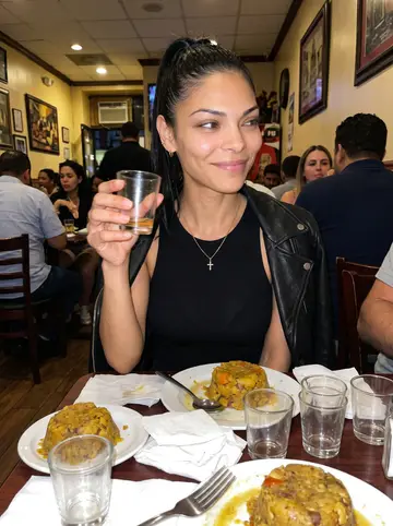 Keila, AI character: a crowded Dominican restaurant near Arthur Avenue, plates of mofongo and small glasses on a narrow table