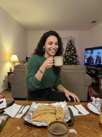 Nadia, AI character: her abuela's living room in Houston during Christmas, old Westerns paused on the TV and a tray of tamales…
