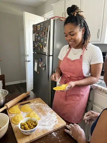 Jada, AI character: at a folding table on her Aunt Pat's back porch in East Point on a Sunday afternoon, a spades game in…
