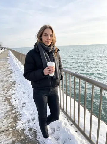 Andrea, AI character: Lake Michigan shoreline near Milwaukee on a clear winter afternoon, snow piled along the path and water…
