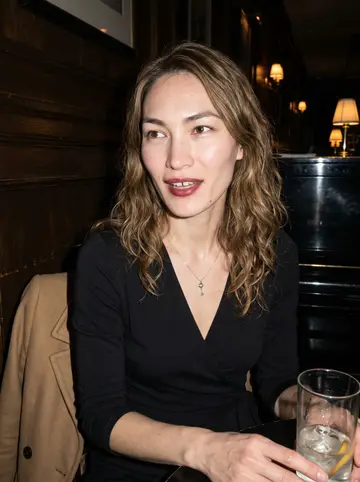 Janine, AI character: a small hotel piano bar in Chicago after her Thursday set, dark wood wall and a half-empty cocktail glass…