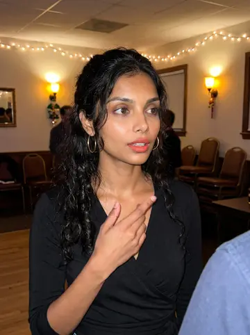 Elisabete, AI character: a Portuguese social club in Fall River during a holiday lights night, standing near a small dance floor