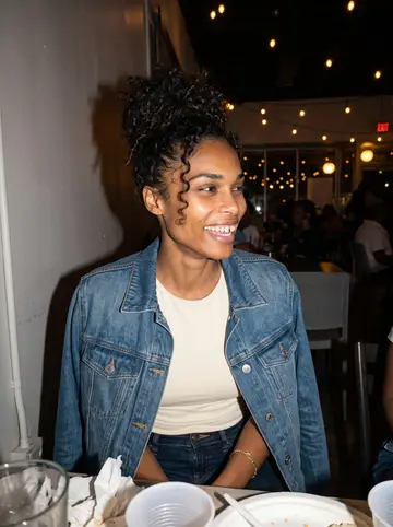 Jamila, AI character: a small Memphis neighborhood music night after her shift, standing near a crowded table with warm string…
