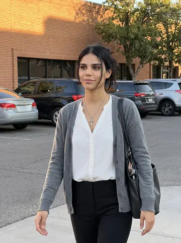 Yoselin, AI character: downtown El Paso after work, outside a low office building near the title company, warm brick wall and…