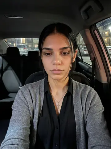 Yoselin, AI character: parked car outside her apartment complex at night, El Paso radio on, dashboard glow and streetlights…