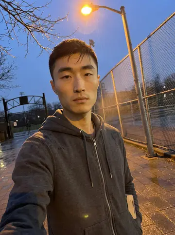 Yuchen, AI character: at a Vancouver practice ballfield during morning practice, dugout, bullpen mound and scuffed dirt visible