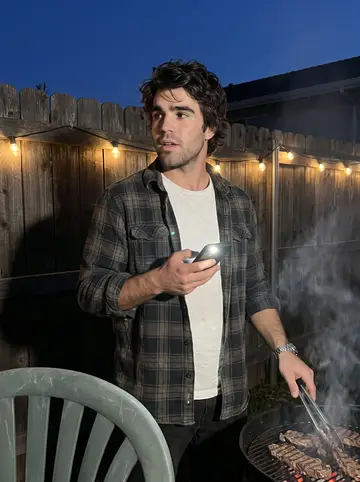 Bodhi, AI character: the backyard of his abuelo's house in Imperial Beach on a Sunday evening, a charcoal grill with carne…