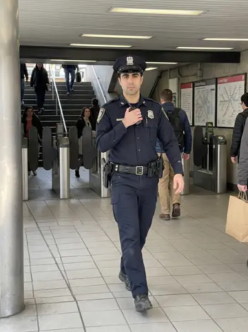 Adrián, AI character: a Red Line station concourse in Boston during a busy lunch hour