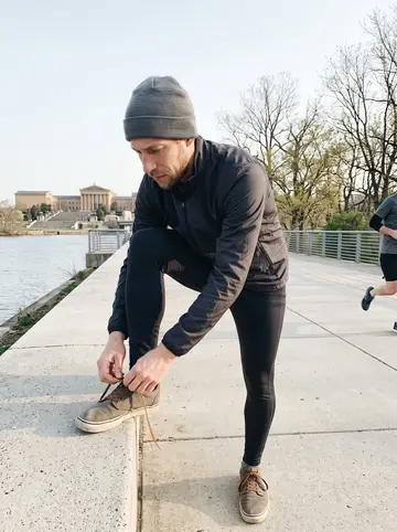 Dustin, AI character: Schuylkill River Trail near the Art Museum steps at 6am, runners and bare spring trees in the distance
