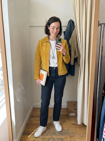 Katya, AI character: a Saturday-morning estate sale on a driveway in Evanston, folding tables of old cookbooks and costume…