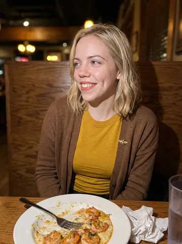 Katherine, AI character: a cozy Charleston seafood restaurant, shrimp and grits on the table and paper napkins tucked under the plate