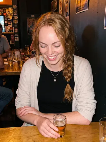 Maria, AI character: a crowded neighborhood bar in Minneapolis after a late café shift, friends cropped at the edges of the frame