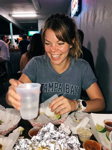 Sabrina, AI character: a busy fish taco counter in St