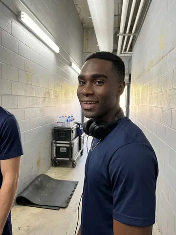 Keon, AI character: arena during afternoon practice, near the home bench with towels and water bottles along the baseline