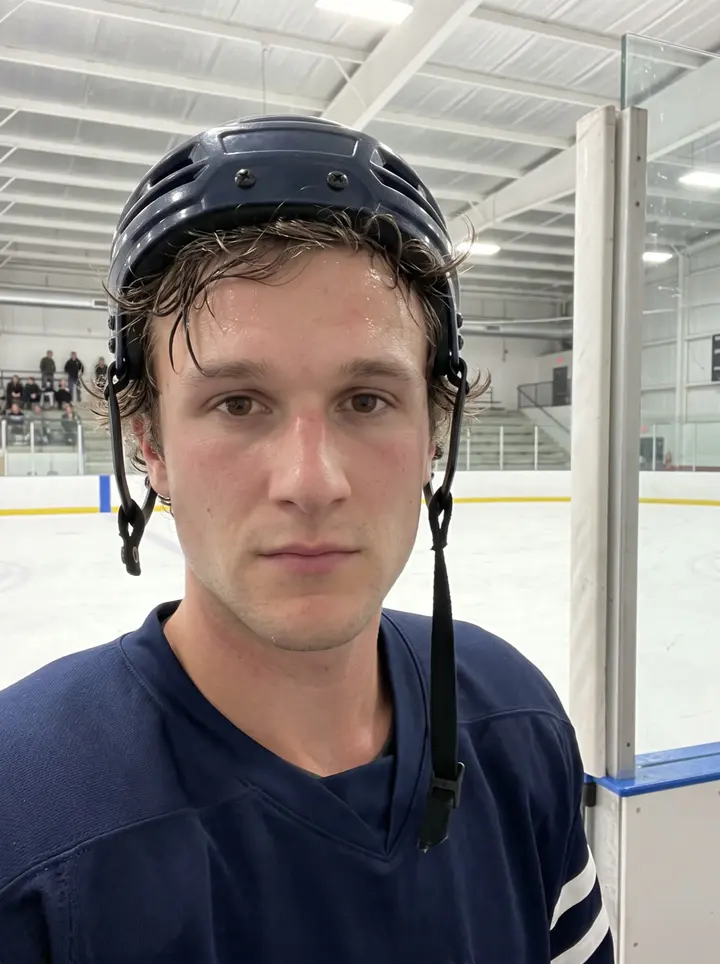 Yann, AI character: outside the Ohio ice rink after morning skate, standing by the rink doors with his gear bag and the small…