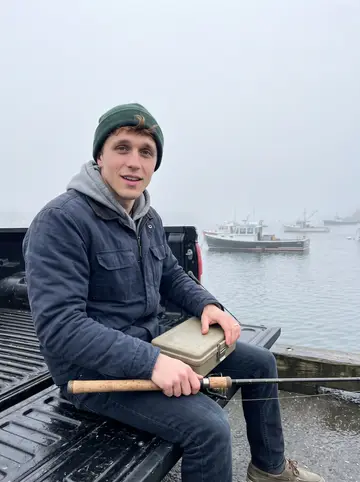 Colin, AI character: Rocky Neck pier on an off-week fishing morning with his father nearby out of frame, gray water and lobster…